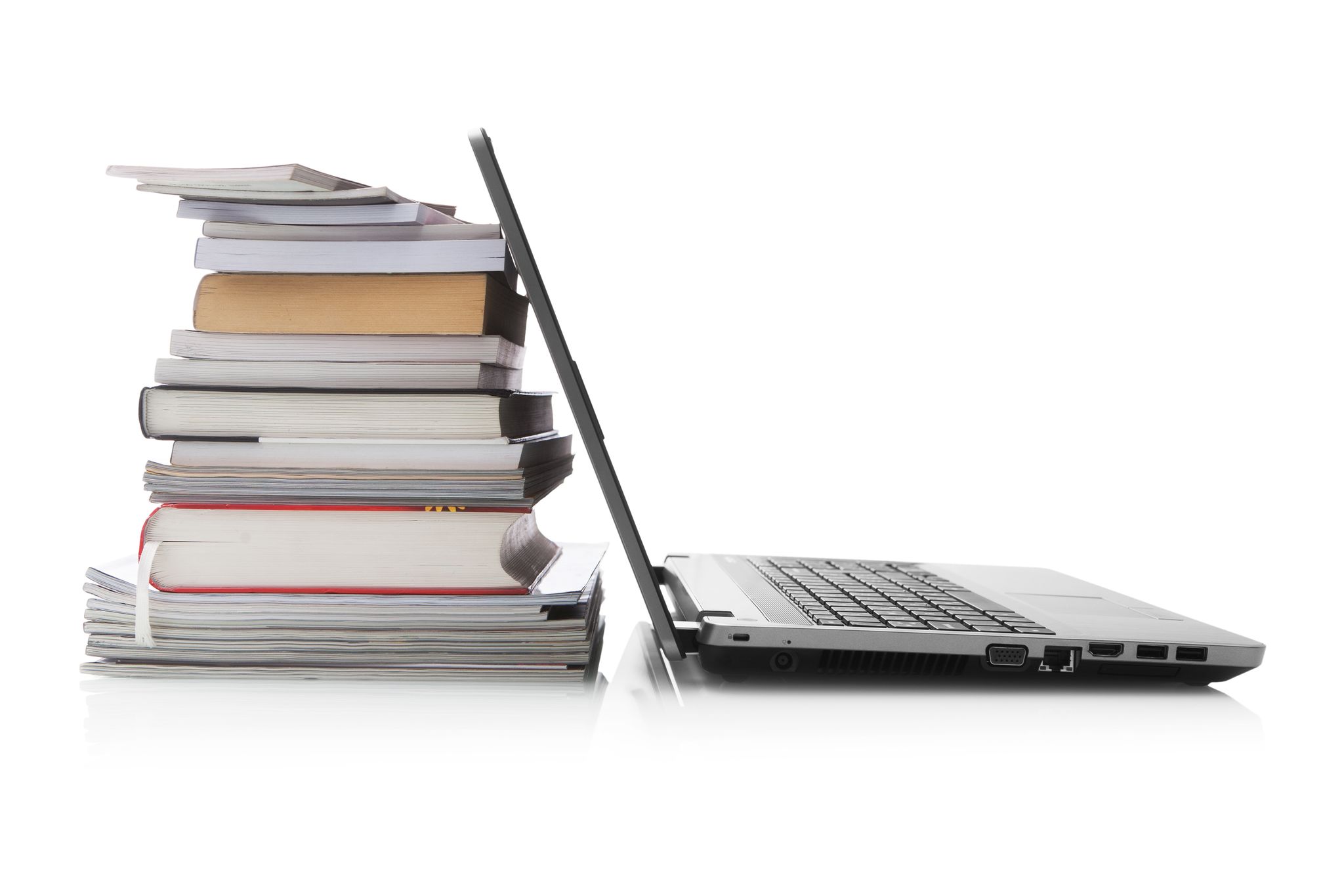 Laptop leaning up against a stck of books