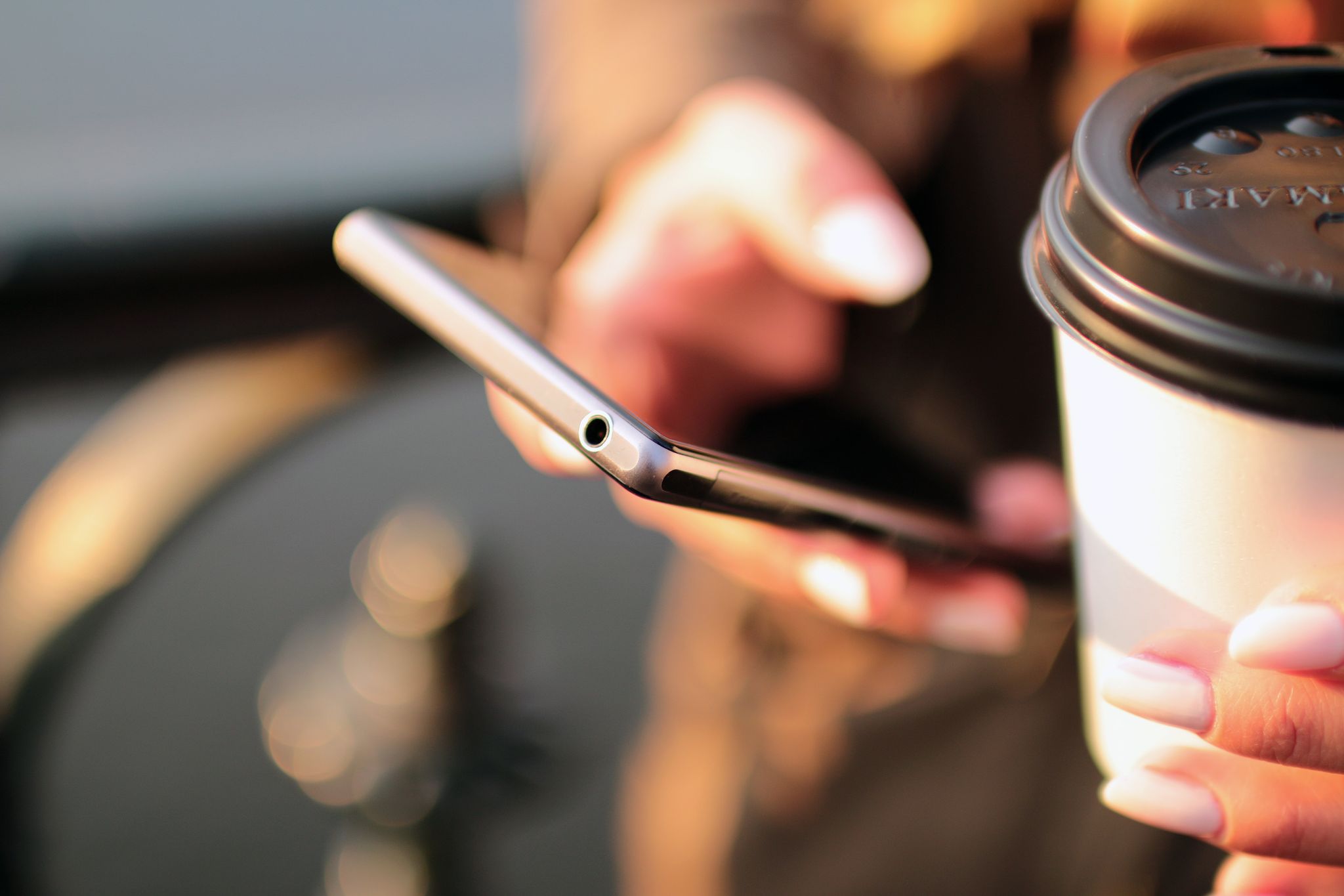 Checking calendar on phone while drinking coffee